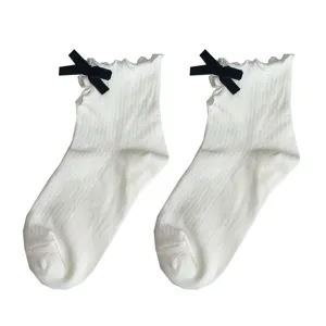 Cute Japanese style white short socks for women with black velvet bow and lettuce edge design.