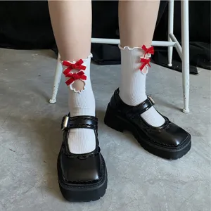 Japanische süße Lolita weiße Rüschensocken mit roten Schleifen und schwarzen Plateau-Schuhen.
