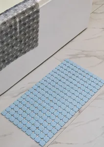 Dettaglio tappetino da bagno in PVC blu, superficie a griglia antiscivolo, drenaggio rapido.