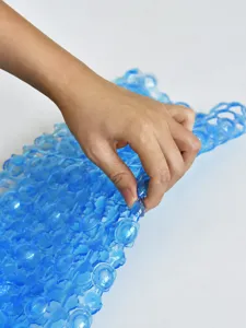 Dettaglio tappetino doccia antiscivolo blu con materiale flessibile e design cavo.