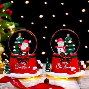 Christmas snow globe detail view featuring cute Santa and snowman with glowing lights.