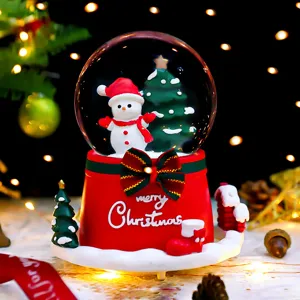 Christmas snow globe ornament with snowman and glowing music box design for holiday gift.