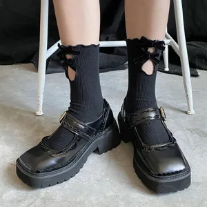Detailed view of cute black JK mid-tube socks featuring cutout bow designs and delicate ruffles.