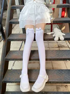 White over-the-knee socks detail shot, featuring cute bowknot decor, soft fabric, sweet style.