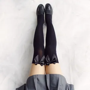 Detailed view of black over the knee socks with satin bows, velvet thin material, stylish JK style.