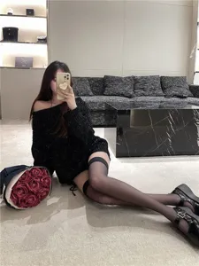 Stylish black knit sweater paired with elegant over-the-knee black stockings for women.