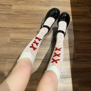 Detailansicht japanischer JK-Stil weiße ausgehöhlte zerrissene Wadenstrümpfe mit roten Schleifen.