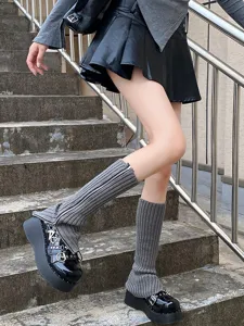 Vue détaillée de jambières en tricot gris avec fermeture éclair sur des marches.