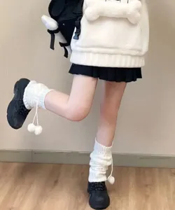 Détail de jambières Lolita de style japonais doux avec des pompons mignons pour l'hiver.