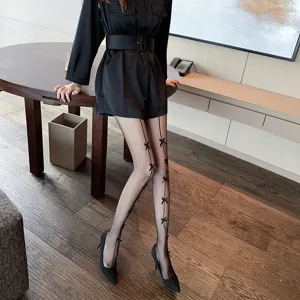 Black fishnet stockings featuring delicate bow details and back seam for women, elegant design.