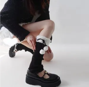 Knit leg warmers with fluffy sherpa cuffs and cute pom-poms for autumn and winter warmth.