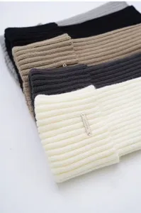 Detailaufnahme gestrickter Beinwärmer mit weicher Rippstruktur und Metalletikett.