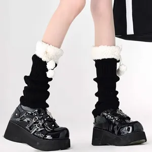 Detailed view of black knitted leg warmers featuring fluffy white sherpa trim and cute pom-poms.