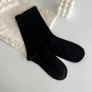Calzini neri a tubo medio, stile minimalista in misto cotone, comfort quotidiano.