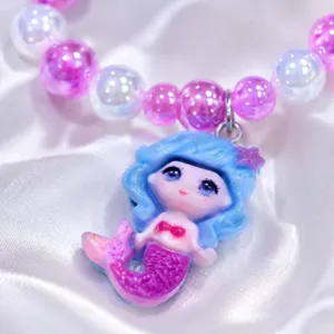Close-up detail of cute cartoon mermaid pendant and sparkly beaded jewelry for kids daily wear.