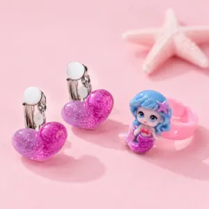 Cute glitter heart clip-on earrings and mermaid ring set, delicate children detail shot.