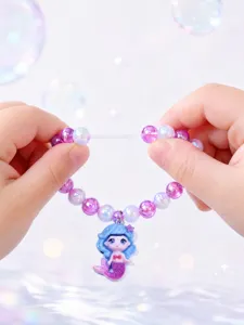 Detail view of children's beaded bracelet featuring a cute mermaid pendant and elastic cord.