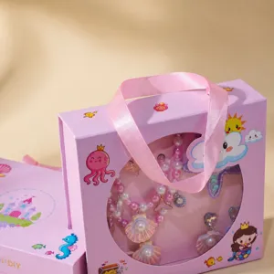 Close-up of a pink gift box containing cute princess jewelry set, shell necklace and bracelet.