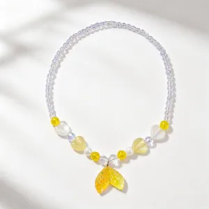 Delicate beaded necklace detail featuring a cute gradient fish tail pendant and pastel beads.