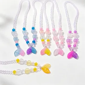 Close-up detail of cute kids gradient mermaid tail beaded necklace with colorful cute charms.