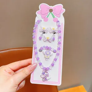 Close-up of children purple pearl necklace bracelet and earrings cute unicorn jewelry set.