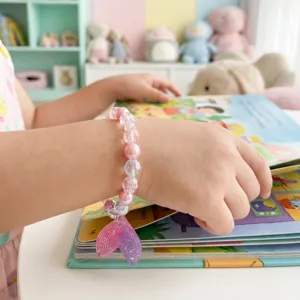 Cute children beaded bracelet detail shot, pink and clear beads with sparkling mermaid tail.