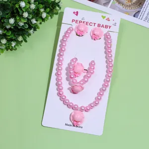 Cute pink pearl necklace bracelet earrings set detail shot, lovely children jewelry accessory.
