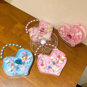 Detail view of heart-shaped children jewelry boxes with cute beads rings and bracelets inside.