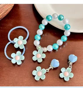 Close-up details of the cute kids floral pearl bracelet, hair ties and clip earrings set.