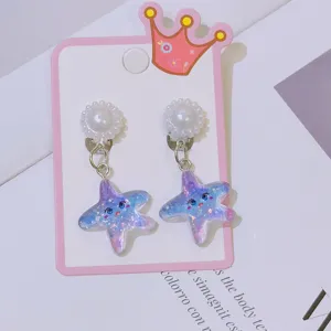 Detailed shot of cute glitter star clip-on earrings with pearl studs for little girls.