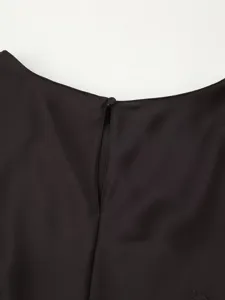 Close-up of black dress back neck detail showing smooth fabric texture and button closure.