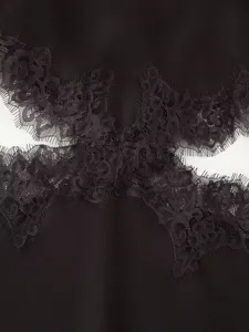 Close-up detail shot of black women dress with elegant lace trim and stylish cutout design.