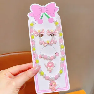 Close-up of cute children cartoon pearl necklace, bracelet and earrings set with unicorn.