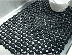 Detailed view of a black PVC kitchen sink mat featuring a non-slip mesh drainage design.