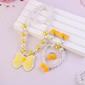 Detailed view of kids pearl jewelry set featuring yellow bows necklace bracelet ring accessories.