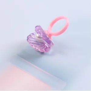 Kids pearl shell ring close up, cute pink purple resin finger jewelry detail view.