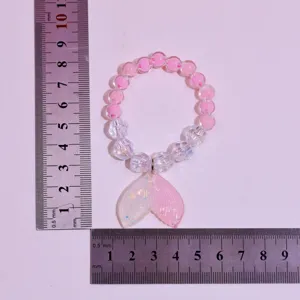 Kids beaded bracelet with cute mermaid tail pendant, pink and clear crystal beads detail view.