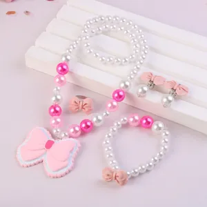 Detailed view of kids pearl necklace, bracelet, ring, and cute pink bow resin charm set.
