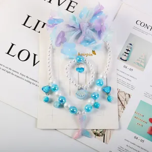 Children mermaid theme jewelry set detail, including necklace, bracelet, earrings and hair clip.