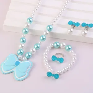 Close-up details of children blue bow pearl necklace bracelet ring earring jewelry set.