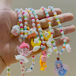 Close-up detail of colorful resin cartoon princess pendants and pearl necklace charms for girls.