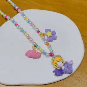 Close-up detail of colorful beaded necklace with cute resin cartoon princess pendant.