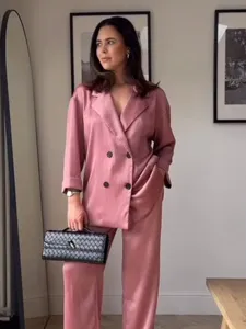 Vista detallada del traje de chaqueta cruzada y pantalon de saten rosa con efecto arrugado