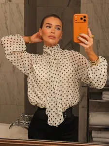 Chic French polka dot long sleeve blouse, high neck tie bow detail, elegant lifestyle shot.