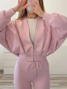 Ensemble de survêtement rose pour femme avec veste bomber zippée et pantalon évasé.