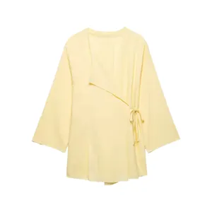 Light yellow linen wrap blouse with v-neck and side tie detail, elegant spring apparel.