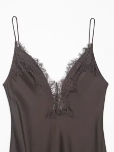 Close-up detail of women's dark satin V-neck slip dress with elegant delicate lace trim.