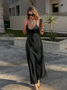 Élégante robe nuisette midi en satin noir, scène de style vacances avec beaux détails.