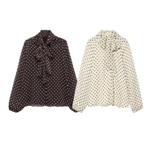 Detailed view of women's long sleeve polka dot blouse with elegant neck bow tie design.