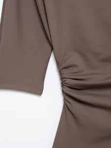 Detailed close-up view of brown stretchy fabric texture and side ruched sleeve design.